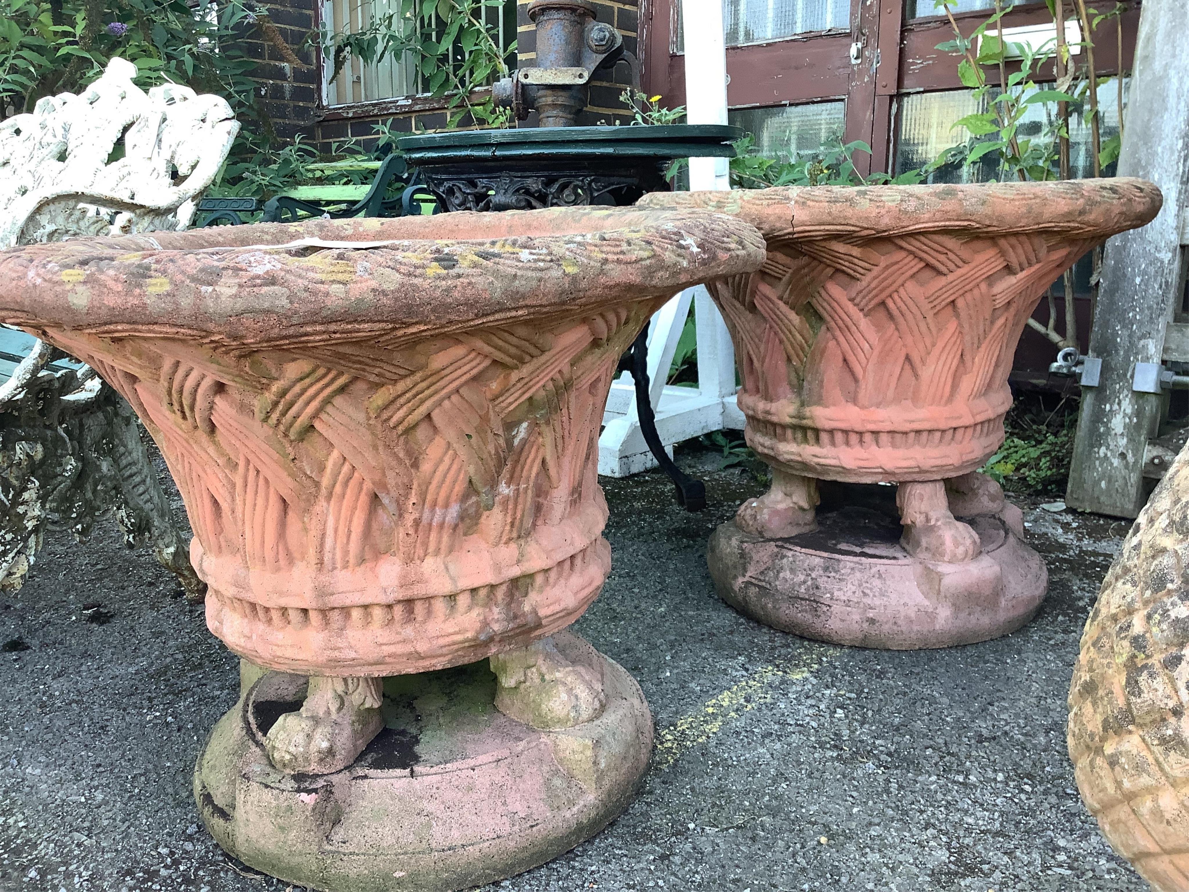 A pair of circular terracotta garden urns with basket weave bodies on lion's paw feet, diameter 72cm, height 60cm. Condition - poor to fair